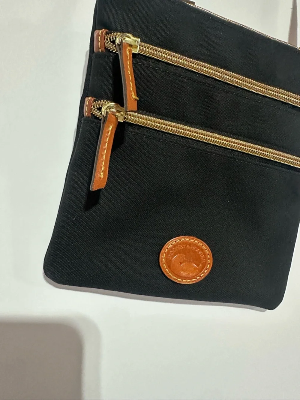 Dooney & Bourke North South Triple Zip Black Crossbody with Brown Leather Strap